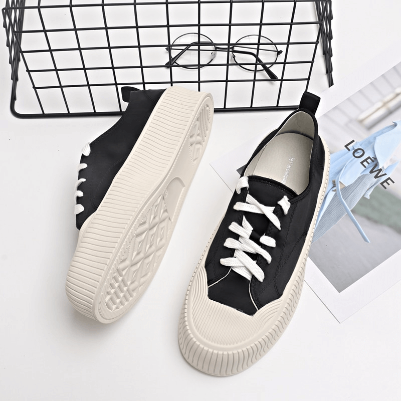 Women's black lace-up casual sports shoes with thick flat soles, featuring a stylish design and durable construction.